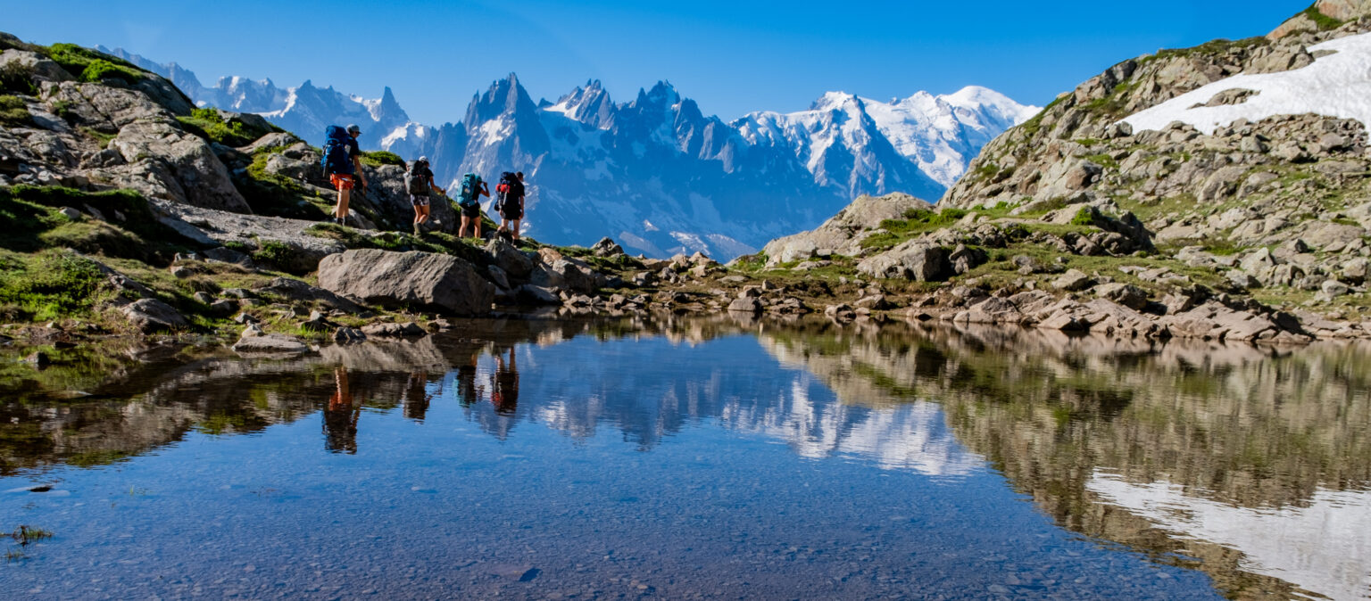 Reflection of hikers in an alpine lake