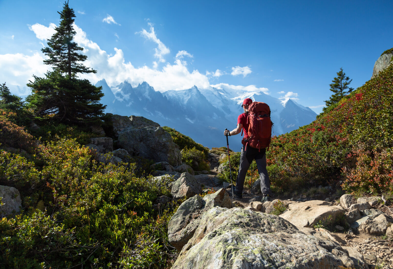 randonneur marchant face au Mont Blanc dans le massif des Aiguilles Rougess