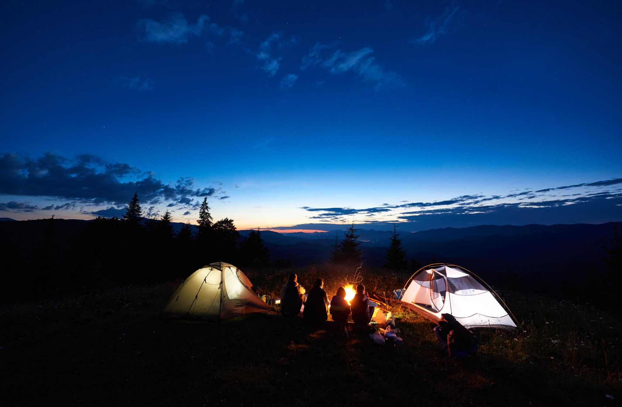 Famille profitant d'un feux de camp face au couché de soleil