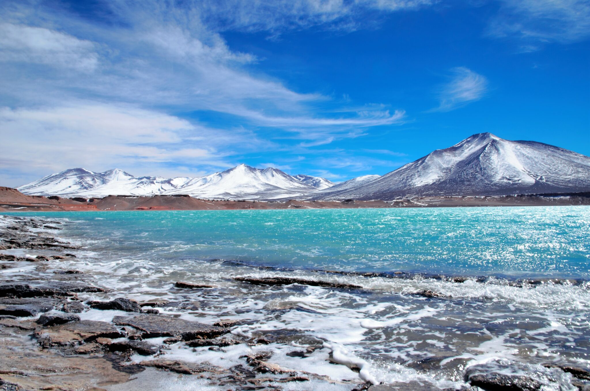 Long shot of the Laguna Verde with turquoise water, mountains in the background and a blue sunny sky in Chile, South America